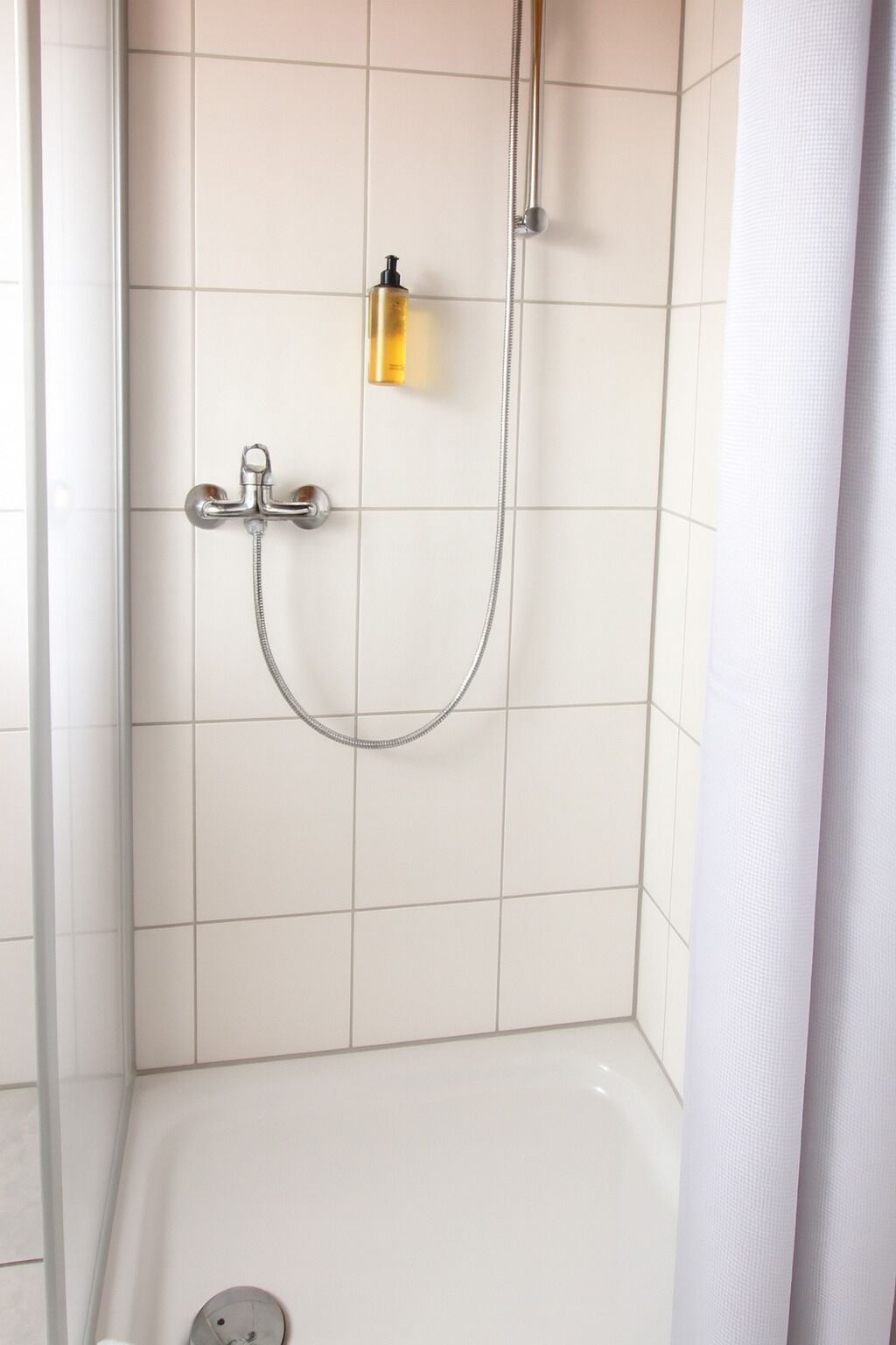 En bruser med brusehoved og en shampoo.