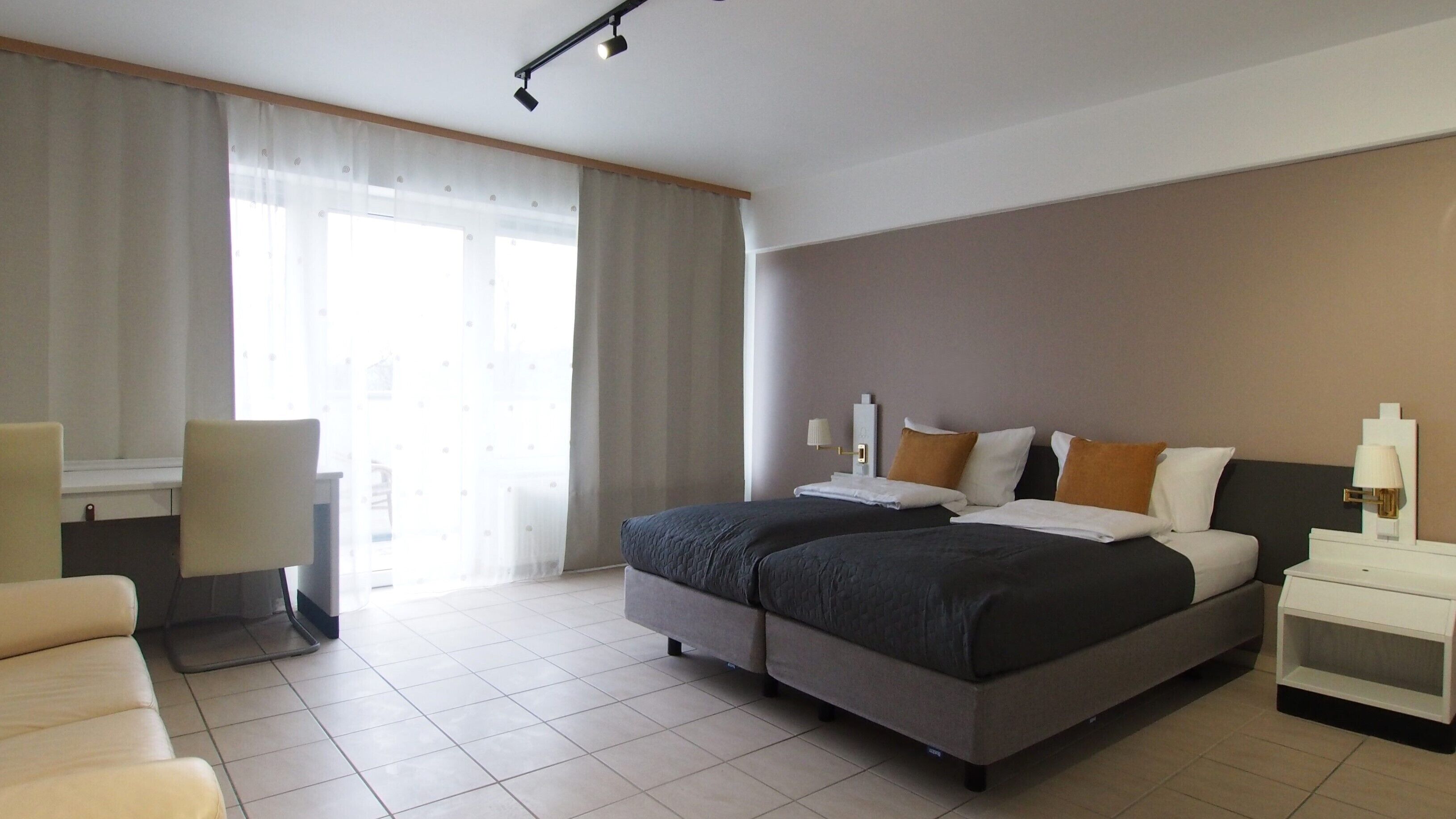 Una habitación de hotel con una cama, un escritorio y una silla.