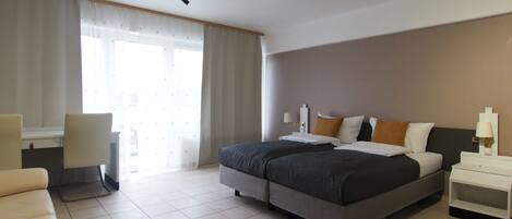 Una habitación de hotel con una cama, un escritorio y una silla.