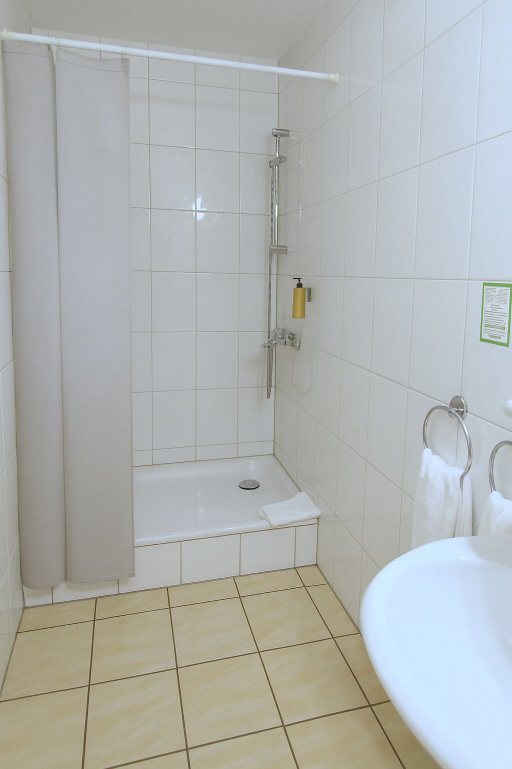 A bathroom with a shower, a sink, and a toilet.