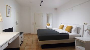 A bedroom with a bed, bedside tables, a desk, and a chair.