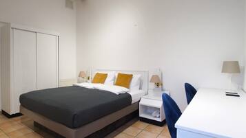 Een hotelkamer met een bed, een bureau en een stoel.