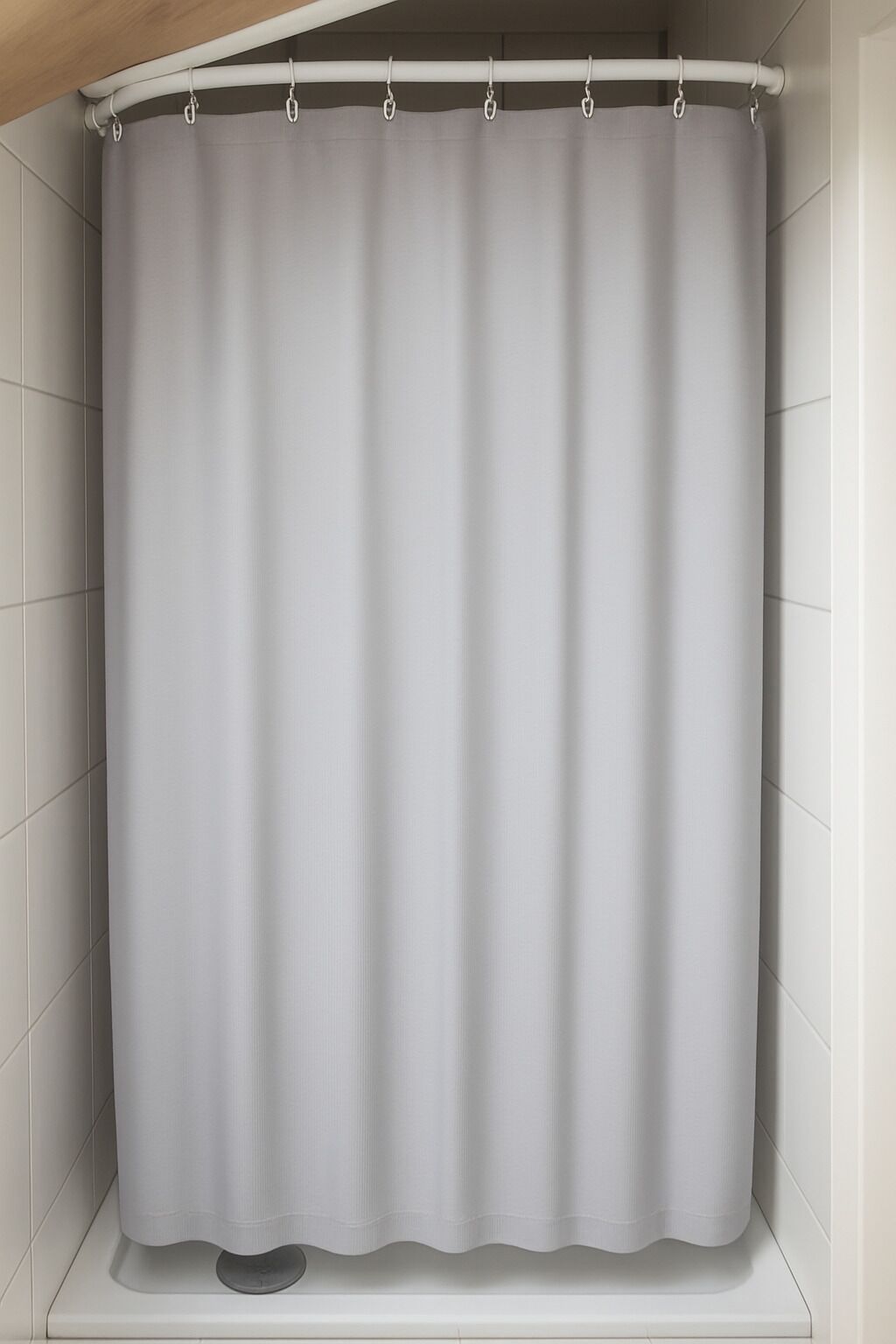 Ducha con cortina blanca y pared de azulejos blancos.