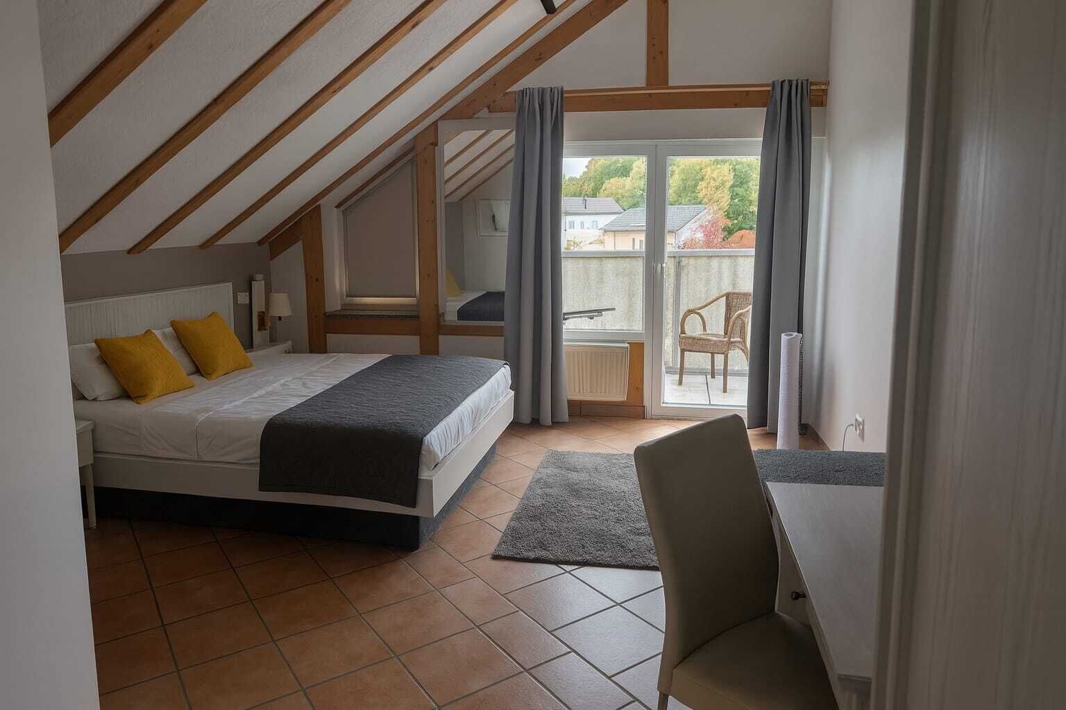 Une chambre à coucher avec un lit, une chaise, une vue sur l’extérieur et un balcon.