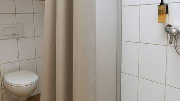 Ein Badezimmer mit Dusche, Toilette und Badewanne.