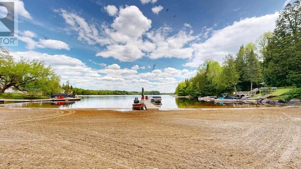 A lakeside property with boats docked, a dock, and a bridge.