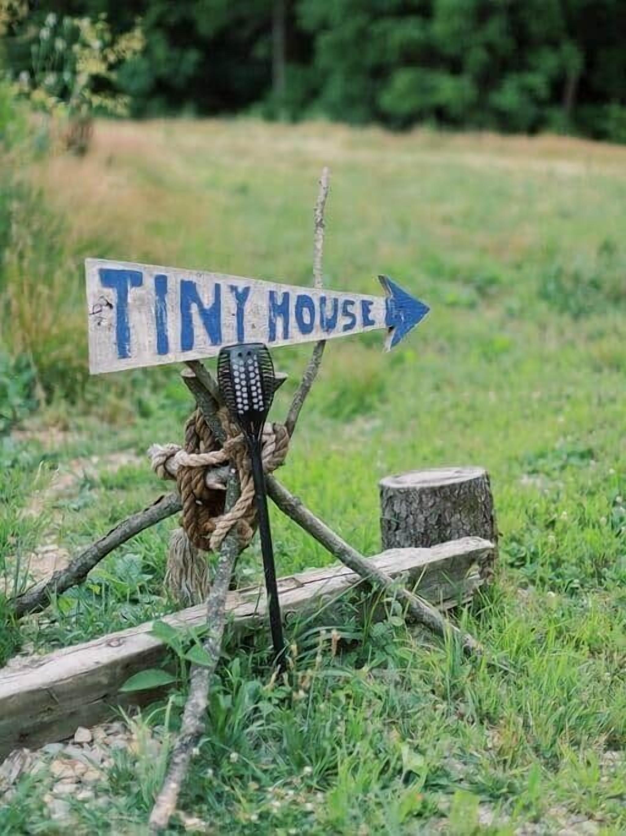 Un viejo cartel rústico señala 'Tiny House'.