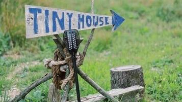 Un viejo cartel rústico señala 'Tiny House'.