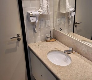 A bathroom with a sink, two hair dryers, a mirror, and a towel rack. - Porto Beach Residence (Ipojuca)