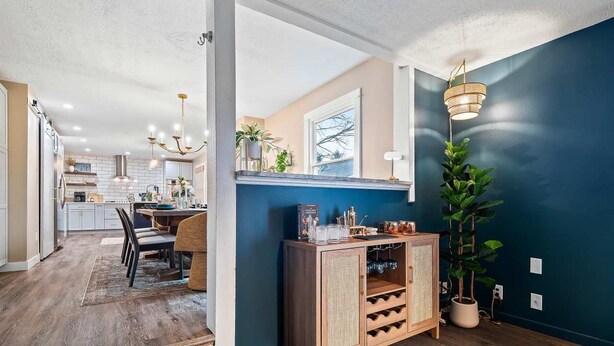 A modern kitchen with a dining area, wooden cabinets, and a large potted plant. - Lake Escape-Pool Table-Kids Game Room-Wii-Foosball (Avon Lake)