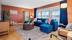 A living room with a blue sofa set, a round coffee table, and a wooden side table. - Lake Escape-Pool Table-Kids Game Room-Wii-Foosball (Avon Lake)