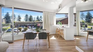 A modern kitchen with a dining area, large windows, and a view of the street. - Sunlit Durham Walk to Glenelg Beach Dining and Bars (Glenelg)