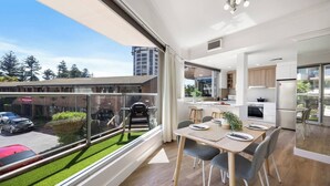 A modern apartment with a balcony, a dining area, and a kitchen. - Sunlit Durham Walk to Glenelg Beach Dining and Bars (Glenelg)