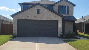 A two-story house with a garage, a driveway, and a well-maintained lawn. - Peaceful 4-bedroom house in charming Katy, Near Energy Corridor, Lagoon, parks. (Katy)