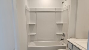 A small, clean bathroom with a bathtub, toilet, and vanity. - Peaceful 4-bedroom house in charming Katy, Near Energy Corridor, Lagoon, parks. (Katy)