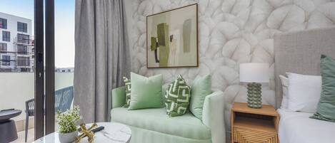 Una sala de estar moderna con un sofá verde, una mesa de centro de mármol y una mesita de noche de madera.