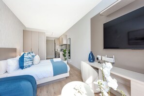 Une chambre d’hôtel moderne équipée d’un lit, d’un bureau et d’une télévision.