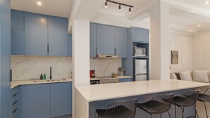 A modern kitchen with blue cabinets, a white countertop, and black bar stools. - Modern Venetian Elegance in CBD (Cape Town)