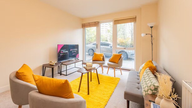 A modern living room with a sofa, armchairs, a coffee table, and a TV. - Bright 2BR Flat • Parking • 1 Min to Tube/Metro • Next to London Museum - Pass the Keys (London)