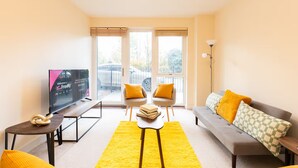A modern living room with a sofa, armchairs, a coffee table, and a TV. - Bright 2BR Flat • Parking • 1 Min to Tube/Metro • Next to London Museum - Pass the Keys (London)