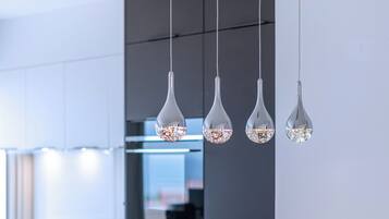 Ein moderner Essbereich mit einem langen Tisch, gedeckt für sechs Personen, im minimalistischen Stil mit dunklen Stühlen und einer hellen Tischdecke.