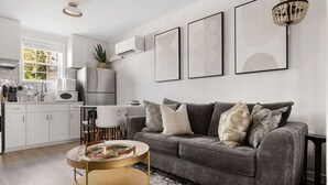 Ein modernes Wohnzimmer mit einem grauen Sofa, einem runden Couchtisch und einer Kronleuchter.