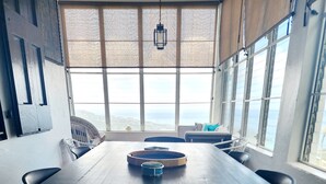 Una sala conferenze con un lungo tavolo, sedie e vista sul mare attraverso ampie finestre.