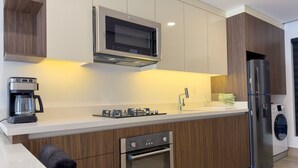 A modern kitchen with a built-in microwave, oven, and refrigerator, a coffee maker, and a washing machine. - Dpto. cerca de Ternium y UANL (Monterrey)