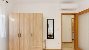 A hallway with a wooden wardrobe, a framed mirror, and a vase with branches. - Tour House – Rio Tinto: Cozy Retreat for a Relaxing Stay (Rio Tinto)