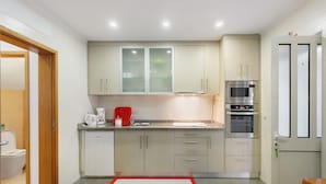 A compact kitchen with a microwave, oven, and coffee maker. - Tour House – Rio Tinto: Cozy Retreat for a Relaxing Stay (Rio Tinto)