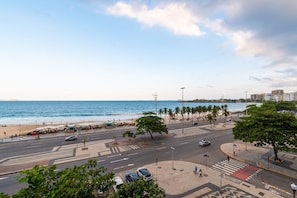 A coastal cityscape with a wide street, palm trees, and a beach in the background. - Studio Beach View in Copacabana A 3196/502 (Rio de Janeiro)