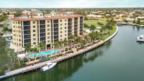 A multi-story hotel with a swimming pool and a dock for boats. - Rare Luxurious 3 Bedroom, 3 Bathroom Condo on Marco Island, FL (Marco Island)