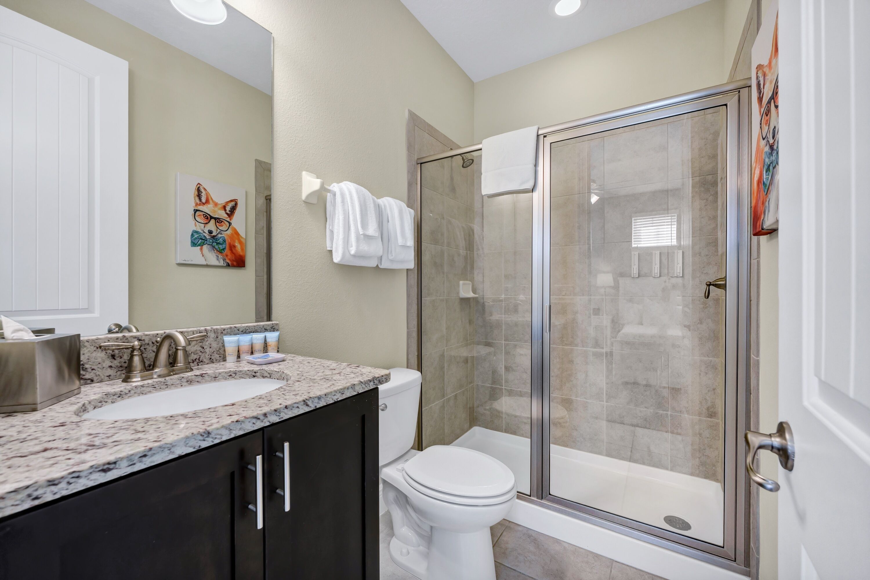 Une salle de bain avec douche, toilettes et lavabo.