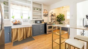 A modern kitchen with grey cabinets, a white countertop, and a built-in oven. - Charming Modern Farmhouse Retreat (Terre Haute)