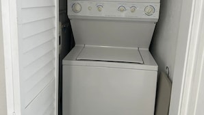 Eine platzsparende Waschmaschine und ein Trockner in einem schmalen Flur.