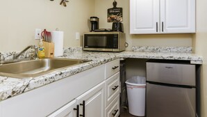 A kitchen with white cabinets, a stainless steel refrigerator, a microwave, and a sink. - Two Tiny Homes, Close to Hiking & Hunting! (Pocatello)