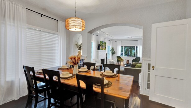 A dining area with a wooden table set for six, surrounded by black chairs. - Private Tropical Garden Home - Walk to Las Olas (Fort Lauderdale)