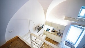 Une cuisine de taille réduite, équipée d’un évier, d’une cuisinière et d’une fenêtre.