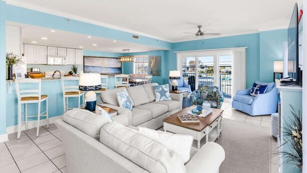 A spacious living room with a large sofa, a coffee table, and a dining area with a kitchen in the background. - The Bayside Oasis at Ocean Bliss | Boardwalk (Ocean City)