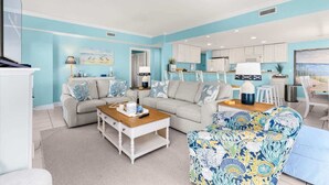 A modern living room with two sofas, a coffee table, and a patterned armchair. - The Bayside Oasis at Ocean Bliss | Boardwalk (Ocean City)