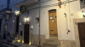 A two-story building with a balcony, a wooden door, and a small window. - Nivèra White Allure Maison · Suite Flùa – Ostuni (Ostuni)