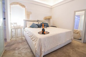 Une chambre à coucher avec un lit, une table de chevet, une chaise et un miroir.