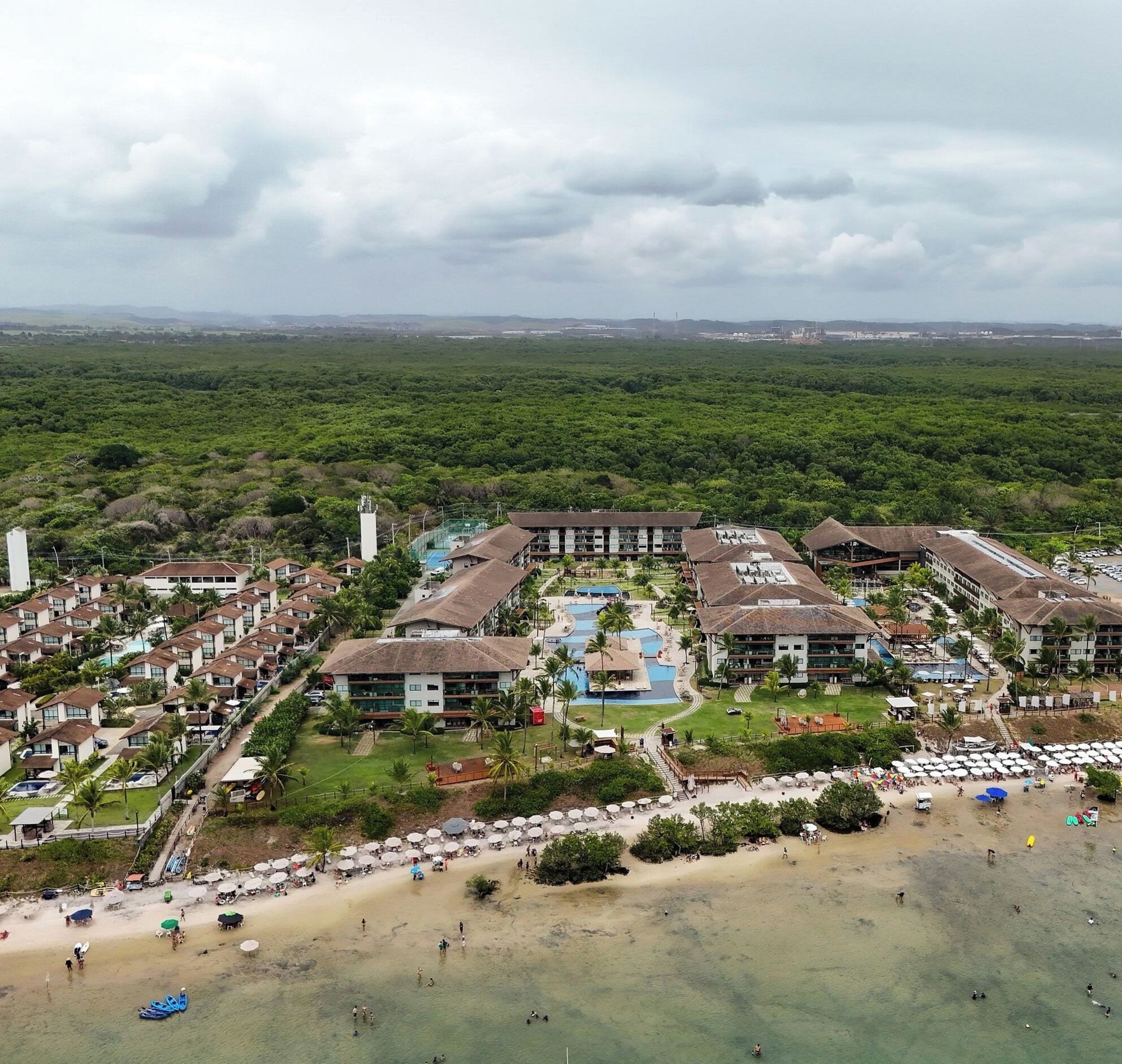 Un resort con diversi edifici, una piscina e una spiaggia.
