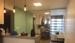 Een moderne keuken met een eethoek, een zithoek en een schuifdeur naar een balkon.