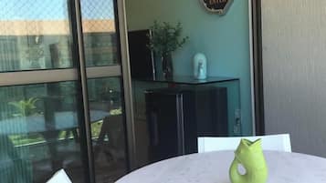 Um quarto com uma mesa redonda, uma cadeira, uma placa decorativa e uma planta.
