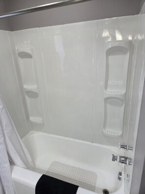 Ein Badezimmer mit Badewanne, Duschbereich und Toilette.