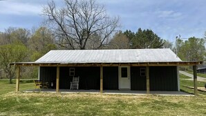 A single-story building with a metal roof and a covered porch.