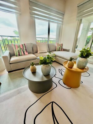 A modern living room with a beige sectional sofa, a round coffee table, and a small side table with potted plants. - Fresh Corner of Serenity 3BR. Laguna (Río Hato)