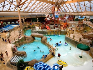 An indoor water park with multiple pools, slides, and play structures. - Woodstone Meadows 4 Bedroom 4 Bathroom Condo at Massanutten Resort (Massanutten)