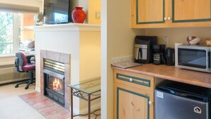 A modern kitchen with a fireplace, a microwave, a coffee maker, and a dishwasher. - Family Studio - 202B (Kelowna)